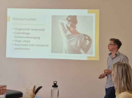 Een groep sporters volgt instructies van een trainer tijdens een training in een sportzaal.